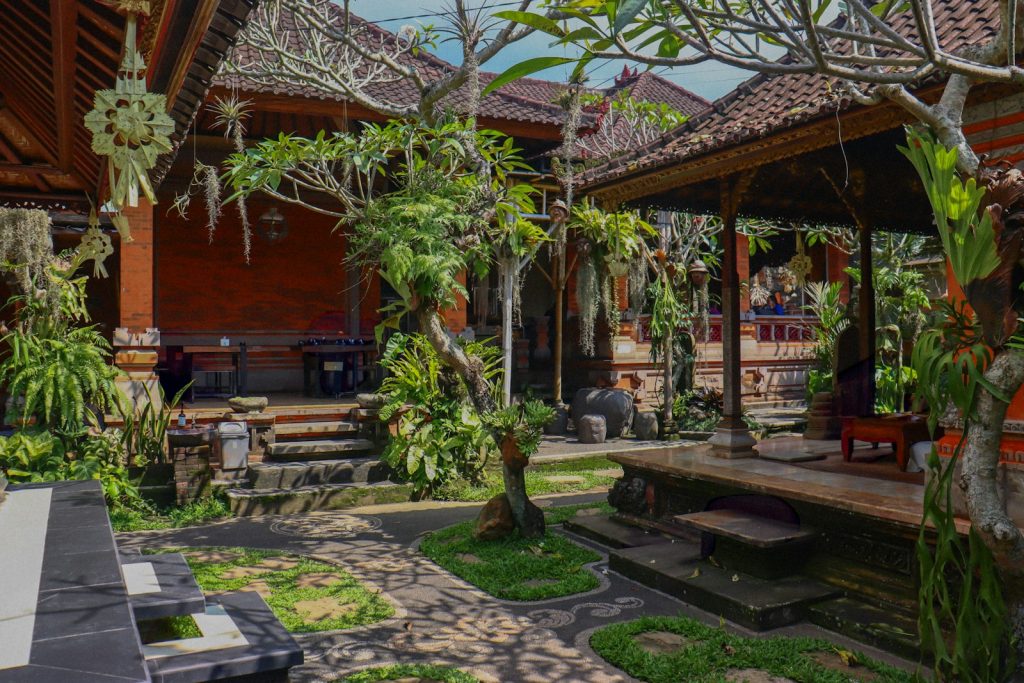 Traditional balinese courtyard with lush greenery and architecture.